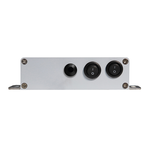 Official product photo of the Koray DM25-2H dual-channel tunable-spectrum 1-10V dimming interface: a silver aluminium control box with corner mounting flanges and three black round controls, including two sealed rocker switches marked I/O for the two dimming channels